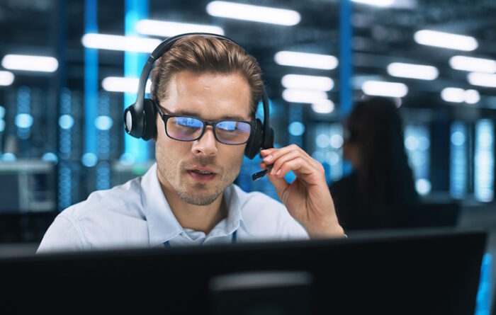 A man in a headset is successfully working together with his team in a call center.