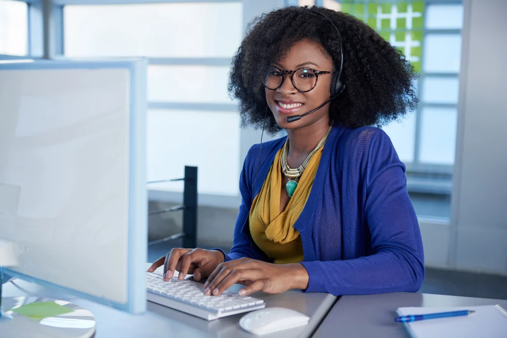 A woman wearing glasses is sitting in front of a computer using OpenFlows HAMMER software to prevent catastrophic events.